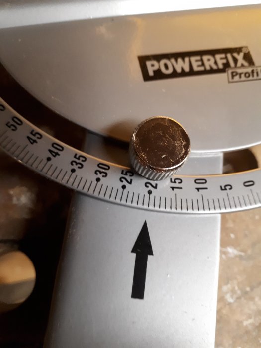 Närbild av en vinkelskala på en Powerfix-verktyg med en pil som pekar på 0 grader och en justeringsratt.