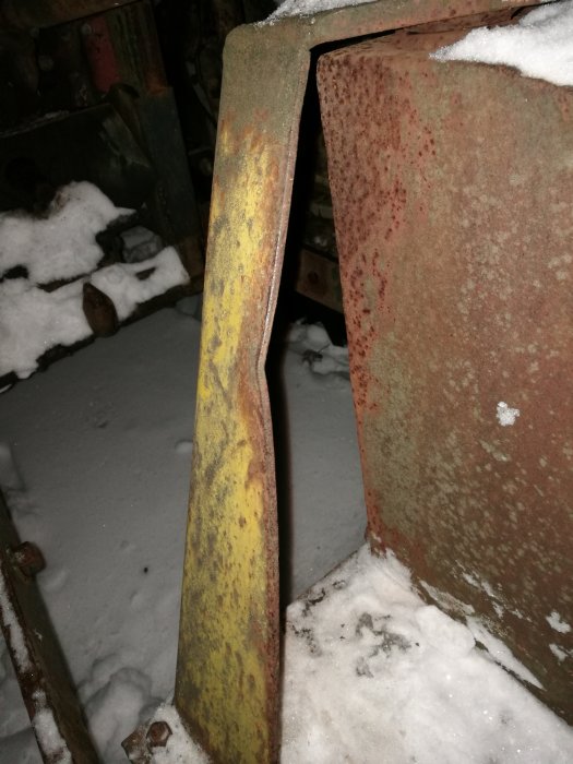 Böjt schaktblad med skada på stag i snöig miljö.
