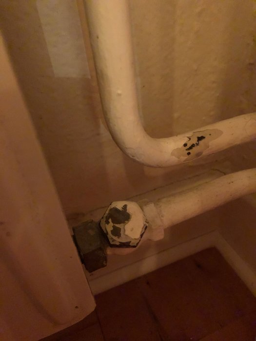 Värmelement med justerbar ventil och synliga rör, viss slitage syns på ventilen.