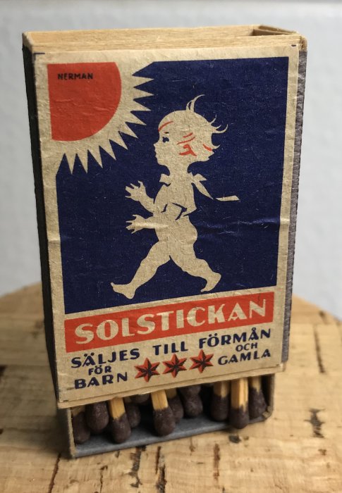 Gammal Solstickan tändsticksask i trä med ikonisk illustration och tändstickor synliga.