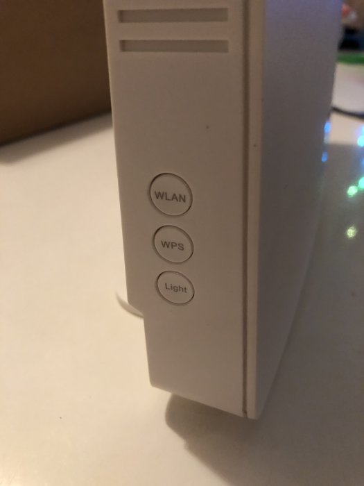 Närbild av en router med knappar för WLAN, WPS och ljusfunktion.