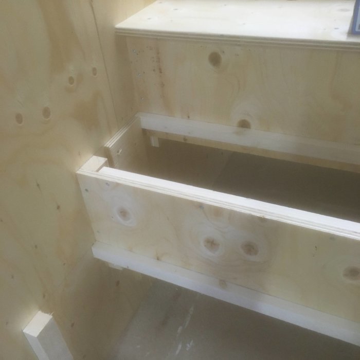 Konstruktion av trätrappa under byggnation med synliga reglar och K-plyfa golv.