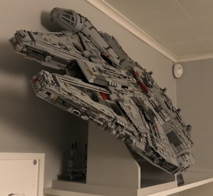 Modell av Millennium Falcon monterad på väggen i ett rum.