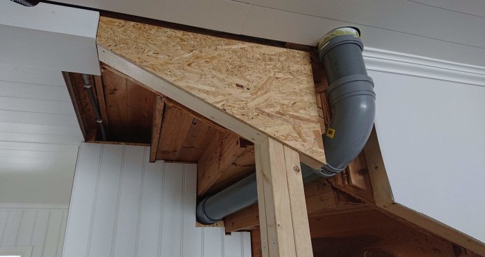 Renoverat hörn av ett rum med nya OSB-skivor och en välorganiserad nätverkssladd i grått rör.