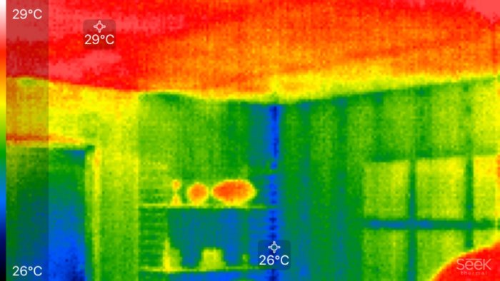 Värmekamerabild av en vägg som visar temperaturskillnader, märkta med 29°C och 26°C, i olika färger från rött till blått.