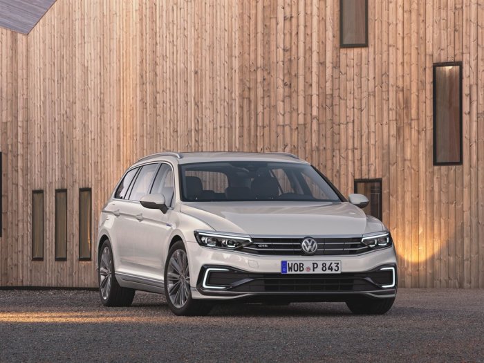 En ny Volkswagen Passat parkerad framför en träfasad, framhäver ökad räckvidd.