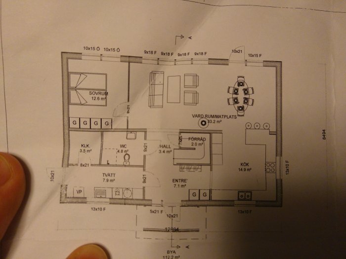 Handritad skiss av nedre plan i ett 1,5-plans hus med markerade rum som kök, tvätt, sovrum och hall.