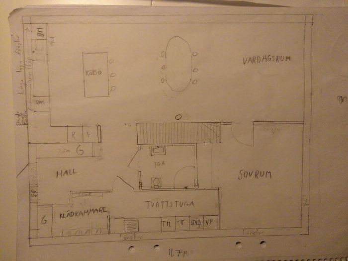 Handritad skiss av en planlösning för nedre plan i ett hus med märkta rum som tvättstuga och vardagsrum.