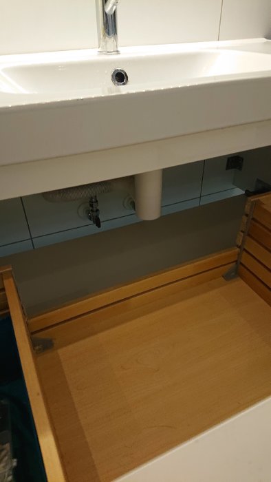 Prevex vattenlås installerat under handfat med synliga rör och anpassad kommodlåda.