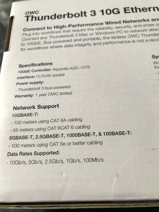 Del av förpackningen för en OWC Thunderbolt 3 10G Ethernet-adapter som visar specifikationer och nätverksstöd.