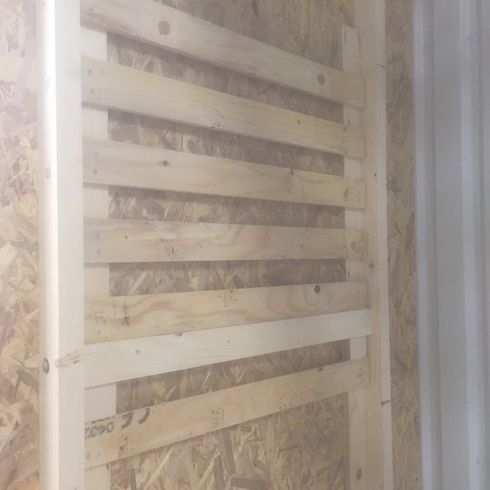 Vägg med hemgjord verktygsförvaring av trä, en variant av fransk klyvskena system för organisation i en verkstad.