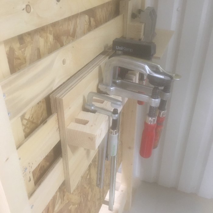 Verktygsorganisering med falsade lister och tvingar på en verktygstavla i en verkstad.