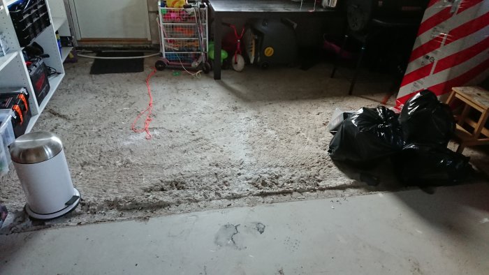 Ojämnt garagegolv med rivna väggar och borttaget uppreglat golv, behöver jämnas till.