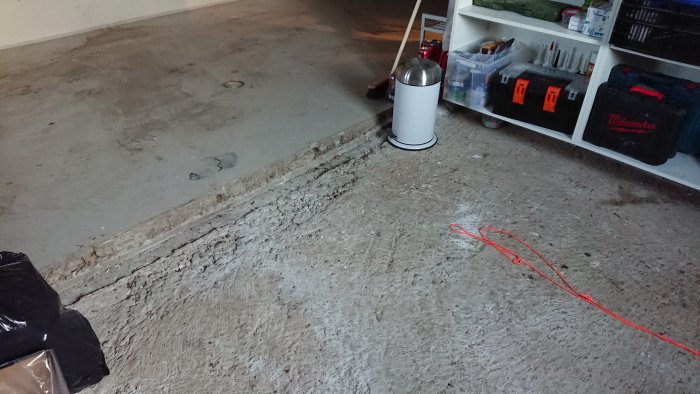 Rivna väggar med ojämnt betonggolv i garage med höjdskillnad som behöver nivelleras.