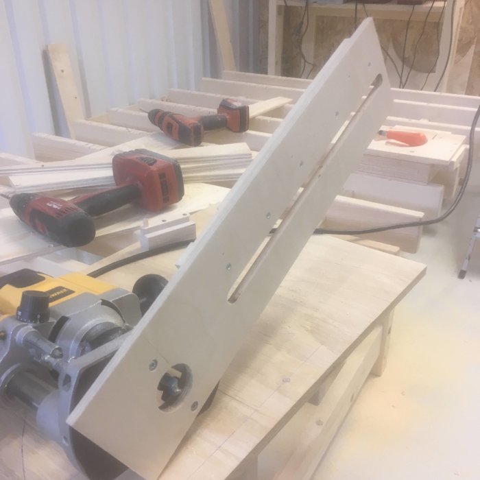 Egengjord träsläplist med knölar på verkstadsbänk bland verktyg.