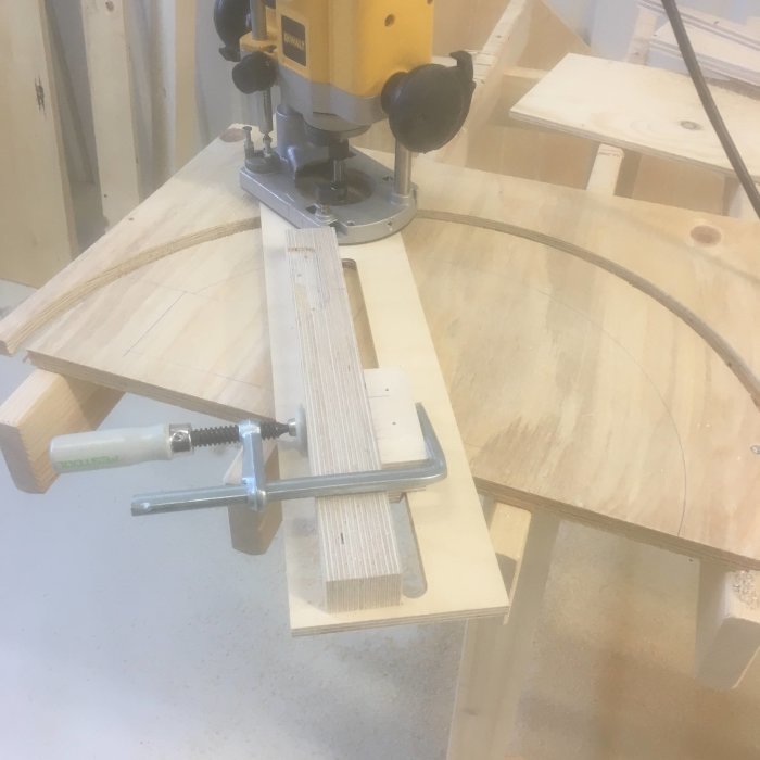 Hemmagjord gadget på träarbetsbänk med cirkelpassare och släplist för att justera luftarmens position.