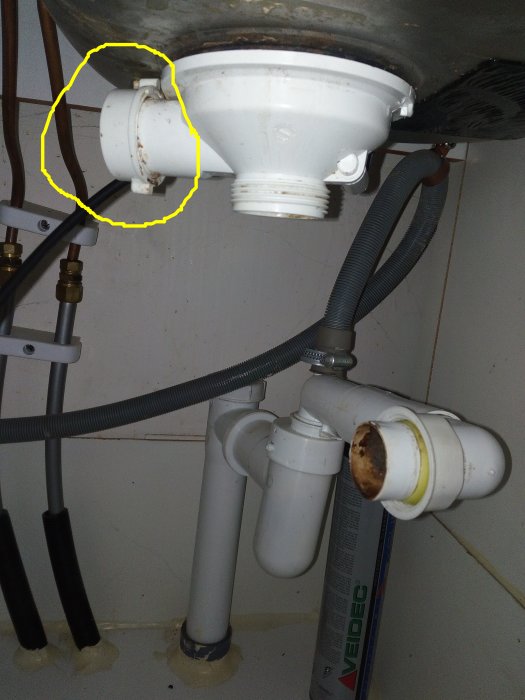 VVS under diskbänk med läcka markerad i rött och platsen för pluggen markerad i gult.