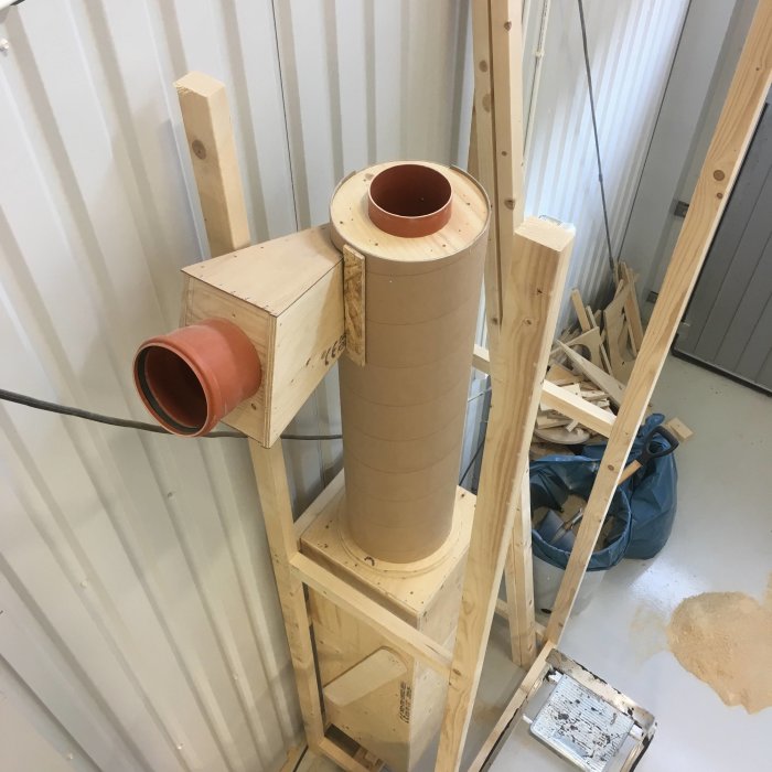 Hemmagjord träspånssug cyklon monterad på ställning i verkstadslokal.