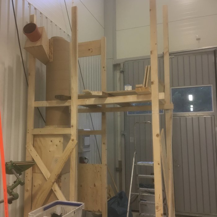 Träställning i verkstad med hängande spånsugscyklon och delar till spånsugssystemet.