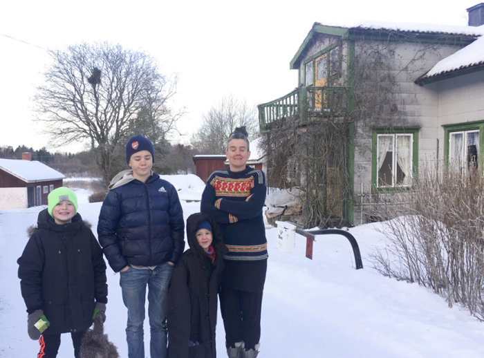 Familj står framför sitt nyinköpta hus med renoveringsbehov under vintern.