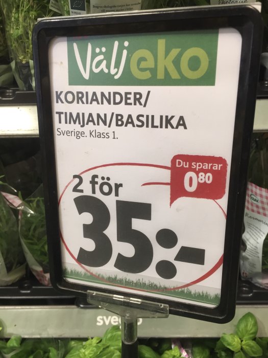 Skylt som erbjuder koriander, timjan och basilika 2 för 35 kr i matbutik.