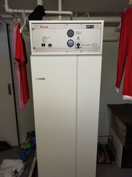 Termoregulator för vattenburet element monterad ovanpå en varmvattenberedare i ett grovkök.