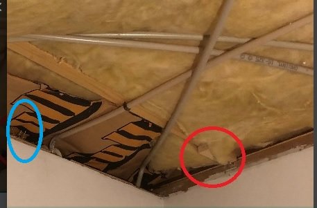 Takstol med en gammal panel markerad med röd ring och spikar markerade med blå ring.