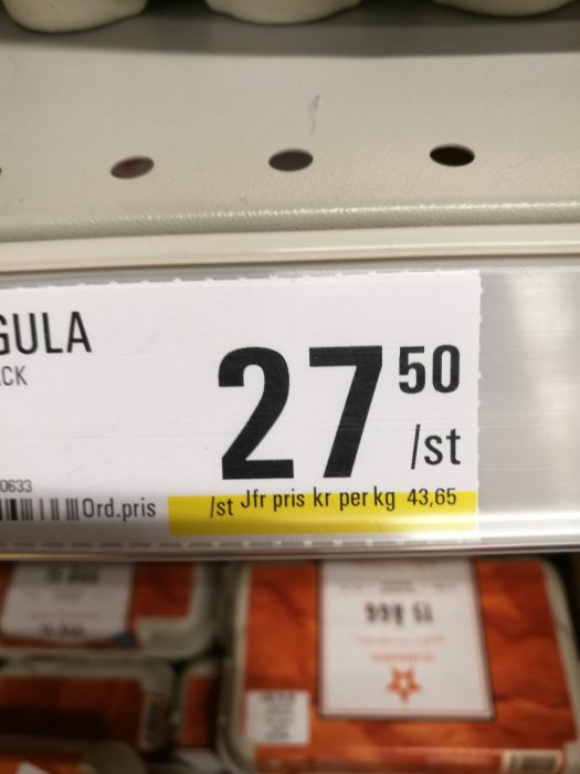 Prislapp visar 27,50 kr/styck med jämförpris på 43,65 kr per kg i butikshylla.