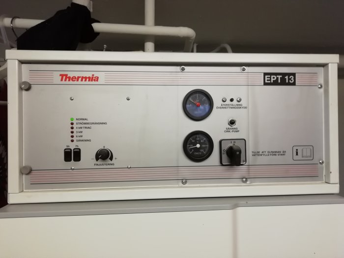 Värmepannans kontrollpanel från Thermia med inställningsknappar, mätare och varningslampor.