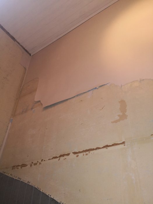 Renovering pågår i trapphus med avlägsnade vägglist och bortriven gammal tapet.
