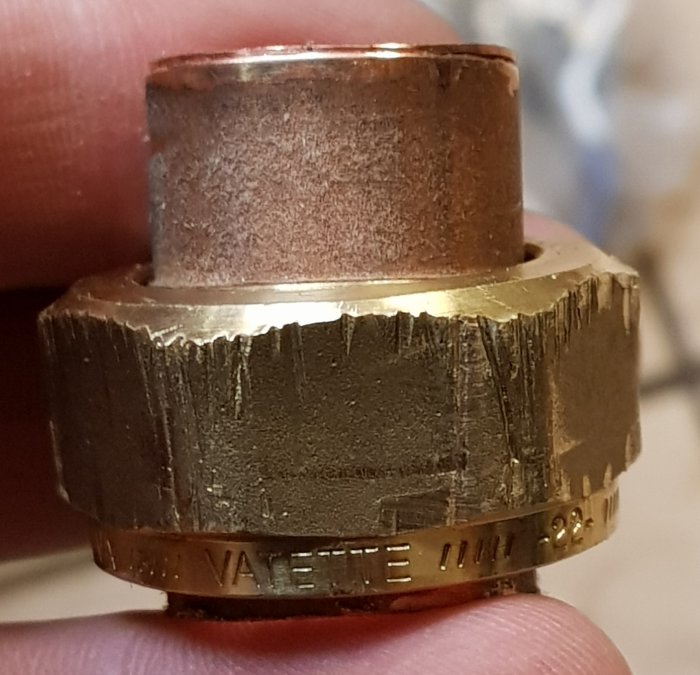 Närbild av en skadad klämringskoppling för 22 mm kopparrör.