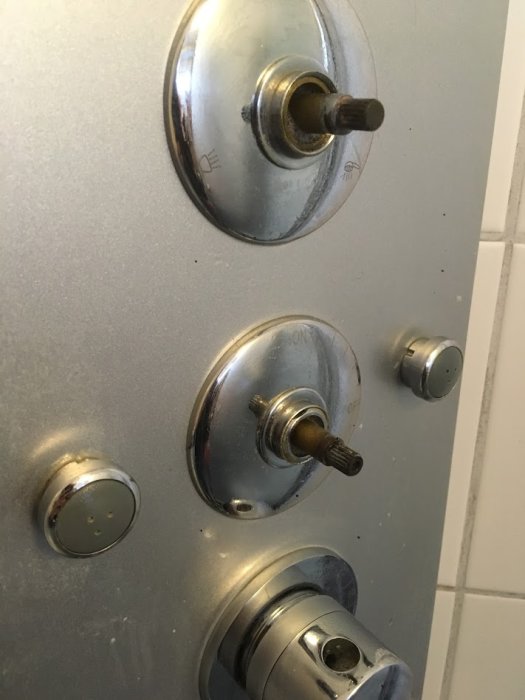 Duschreglage med två avtagande knoppar och en fastsatt nederst på metallpanel.