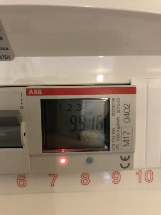 Elmätare med digital display som visar 9915 kWh förbrukning och en blinkande röd lampa.