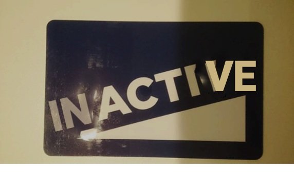 Skylt med texten "INACTIVE" på en mörkt bakgrund, möjlig Photoshop-manipulering.