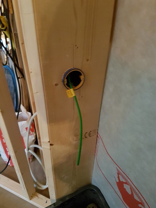 Installation av KNX-kabel genom vägg med kopplingspunkt i golvvärmeskåp under byggnadsrenovering.