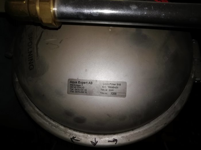 Grått Göingefilter märkt med "Aqua Expert AB" och "Löck Filter 315" med teknisk information och årtal 2000.