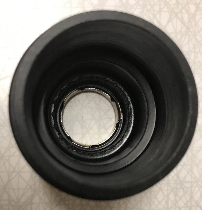 Isärplockade delar av en produkt med synlig fjäder inne i en svart plastkomponent.