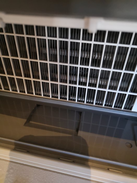 Vy inuti Electrolux torktumlare som visar kondensorgallret ovanför vattenfylld botten, ej utdragbar.
