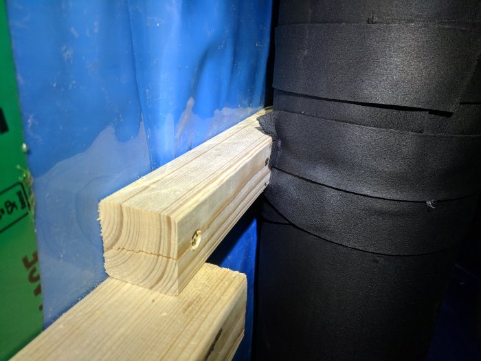 Isolerade FTX-ventilationsrör monterade mot träregel i byggprojekt.