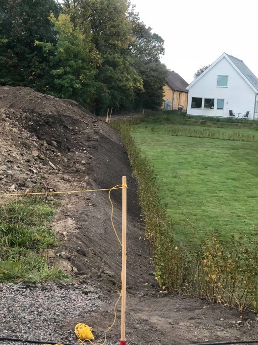 Ny gränsdragning med förändrad slänt och förflyttad häck vid en tomtgräns.