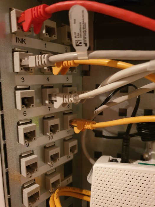 Nätverkspanel med numrerade uttag och uppkopplade Ethernet-kablar.