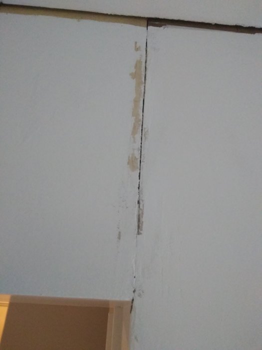 Glipa mellan masonitskivor i ett hörn under renovering.