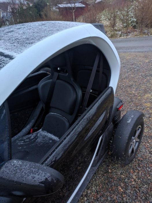 Renault Twizy utan fönster parkerad ute med snö och fukt inuti.