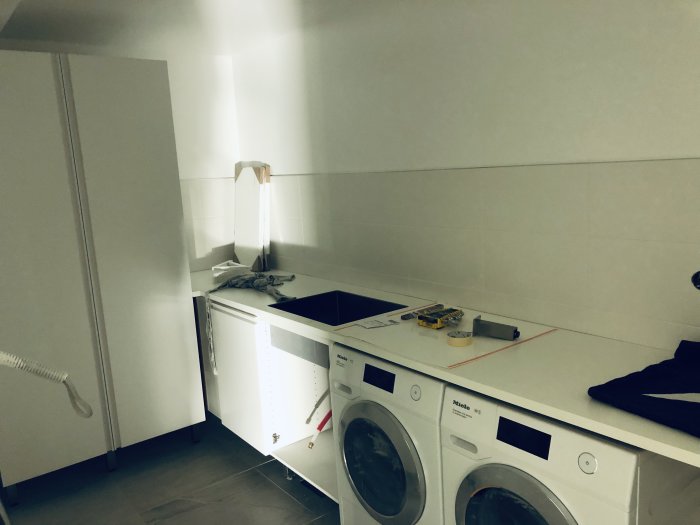 Ett pågående köksrenoveringsprojekt med installerade vitvaror och bänkskiva.