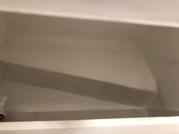 Vitmålad ventilationsschakt i betong sedd från underifrån, med synlig inmurad ventilationskanal.