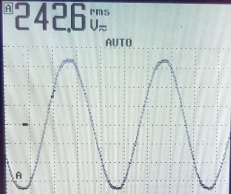 Oscilloskopbild av växelspänning med toppvärde 242.6V rms mot bakgrund av rutnät.