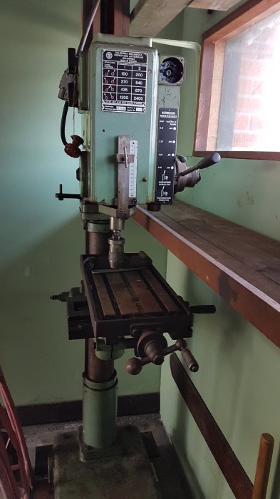 Industriell pelarborrmaskin i ett verkstadsutrymme som ska transporteras hem.