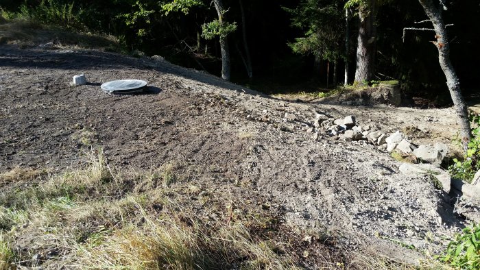 Installation av en backventil i ett uppgrävt område med synliga rör och en brunnlock till vänster i bild.