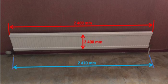 En dubbelpanelradiator på 2400x300 mm med mätta avstånd mellan rören i en renoverad källare.