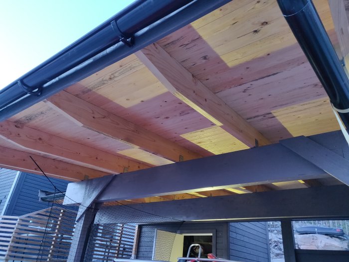 Utsida av carporttak med synligt råspont och balkar, vissa delar med svartmögel.